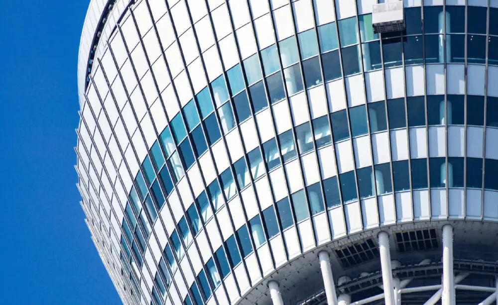 Close-up of a modern glass building with curved, reflective windows.